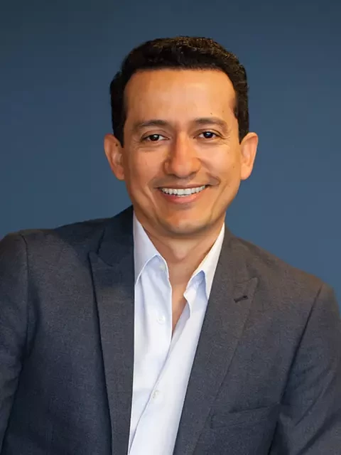 Oscar Moncada in a suit smiling for the camera as Top Cloud Service Provider